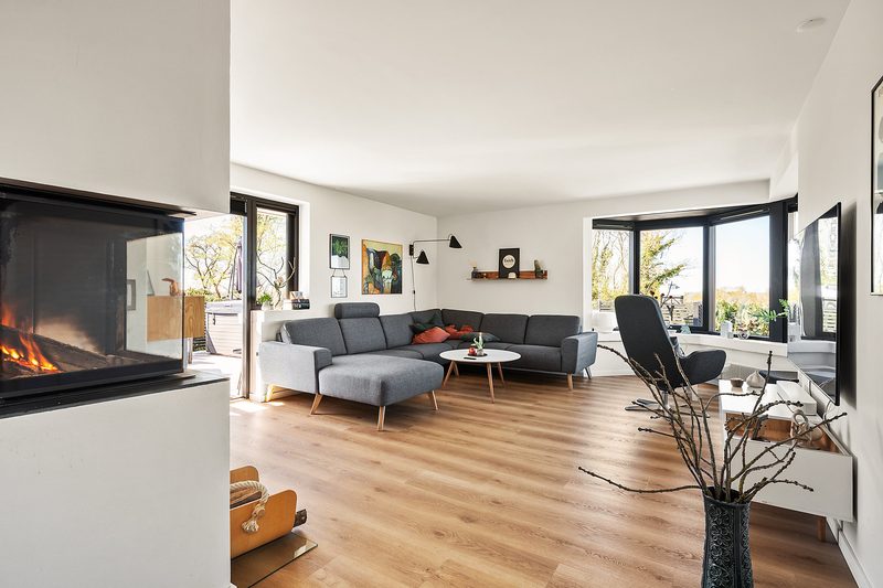 Stuen med sofa, brændeovn og karnap